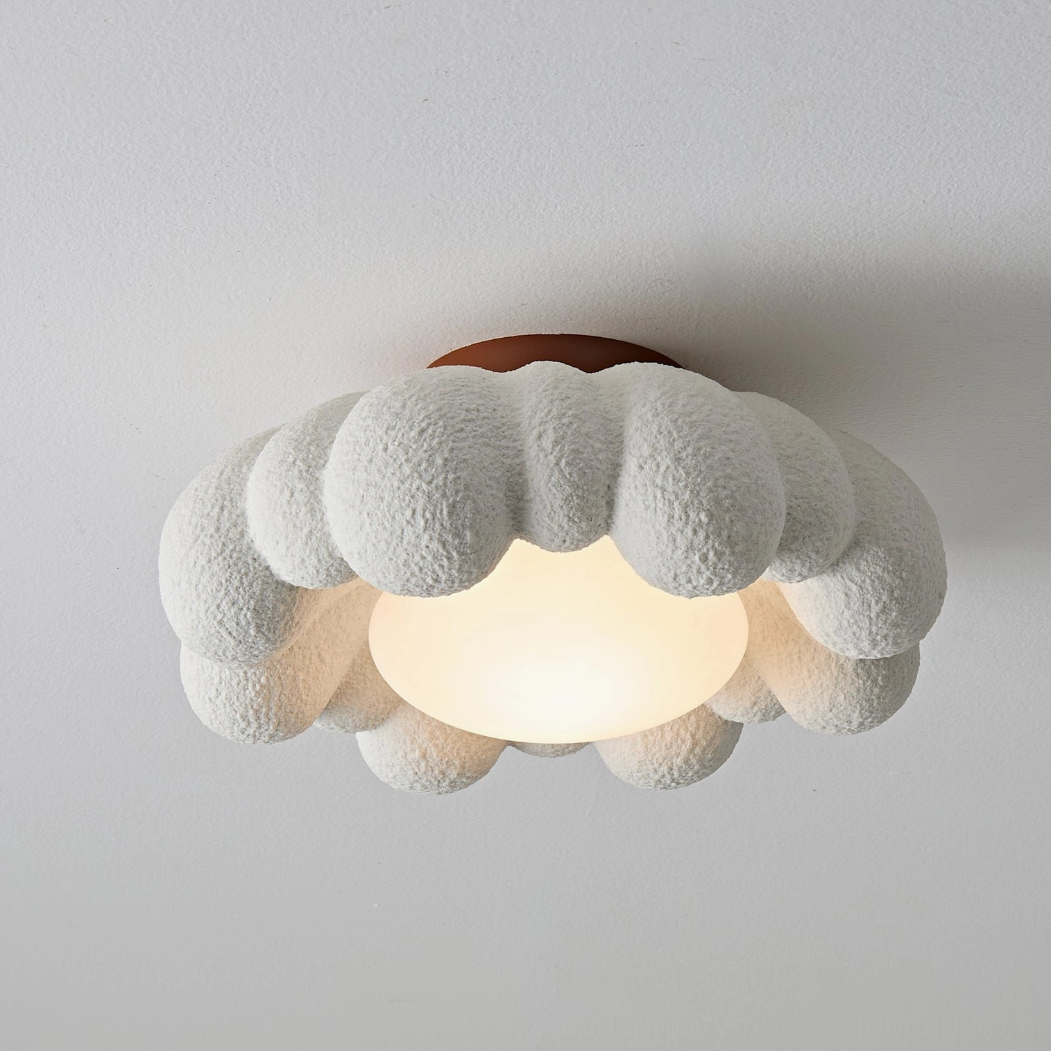 Gross cloud ceiling light with glowing warm LED, medium frame size, terracotta installation base, flat overhead angle