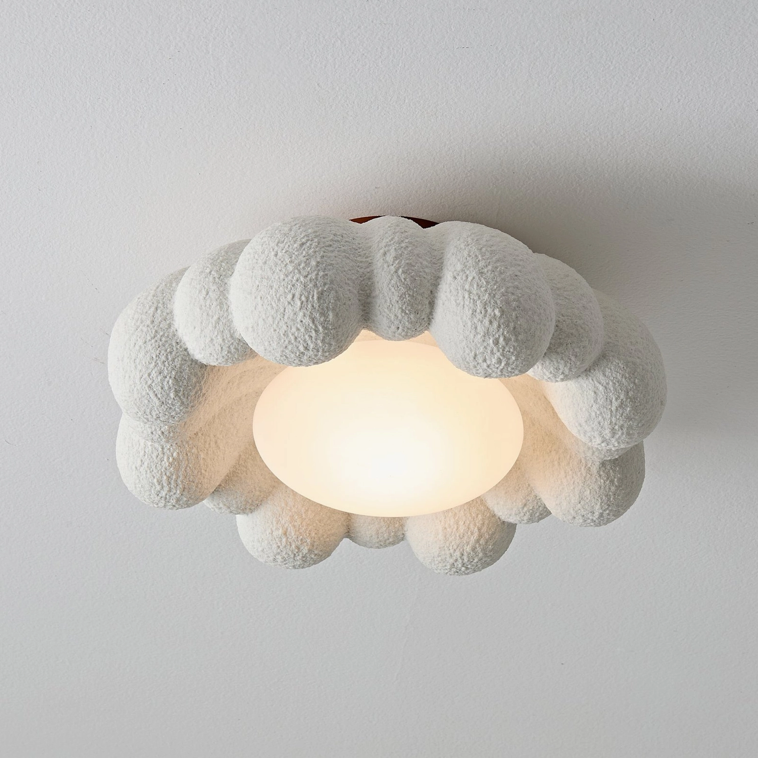 Large Gross cloud-shaped flush mount ceiling light with illuminated warm LEDs, terracotta base, architectural view