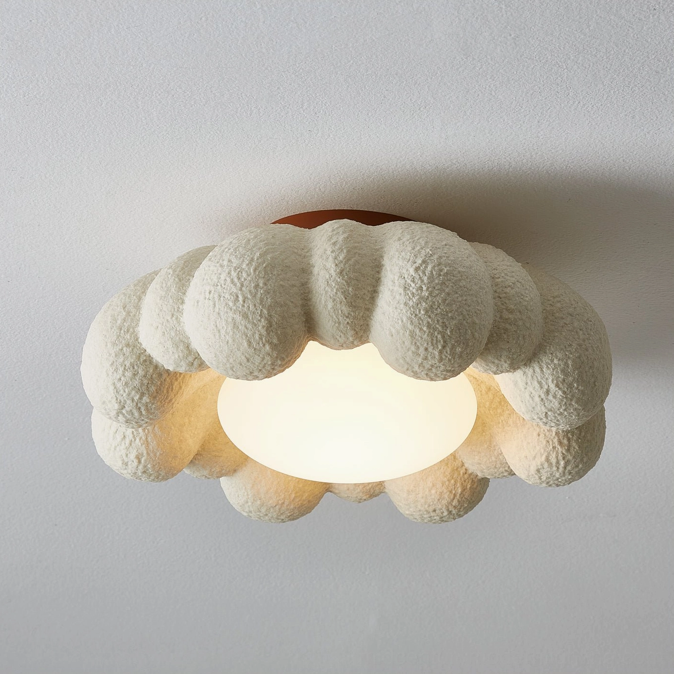 Large Gross cloud ceiling light fixture installed on terracotta base with warm LED illumination, architectural flat view
