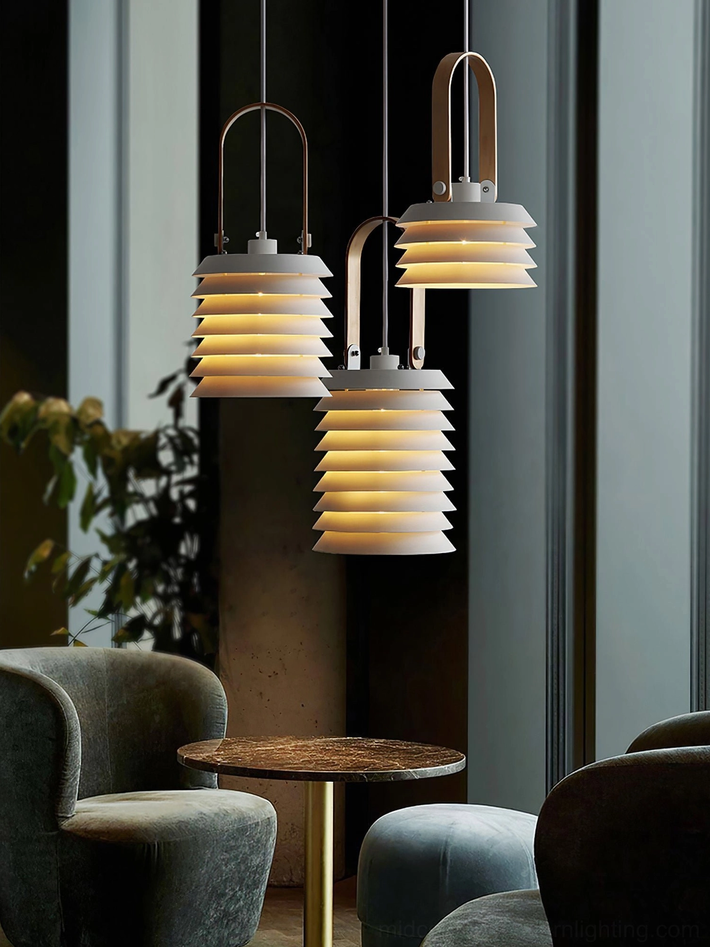 Set of three tiered pendant lamps creating soft warm ambient lighting in casual lounge area