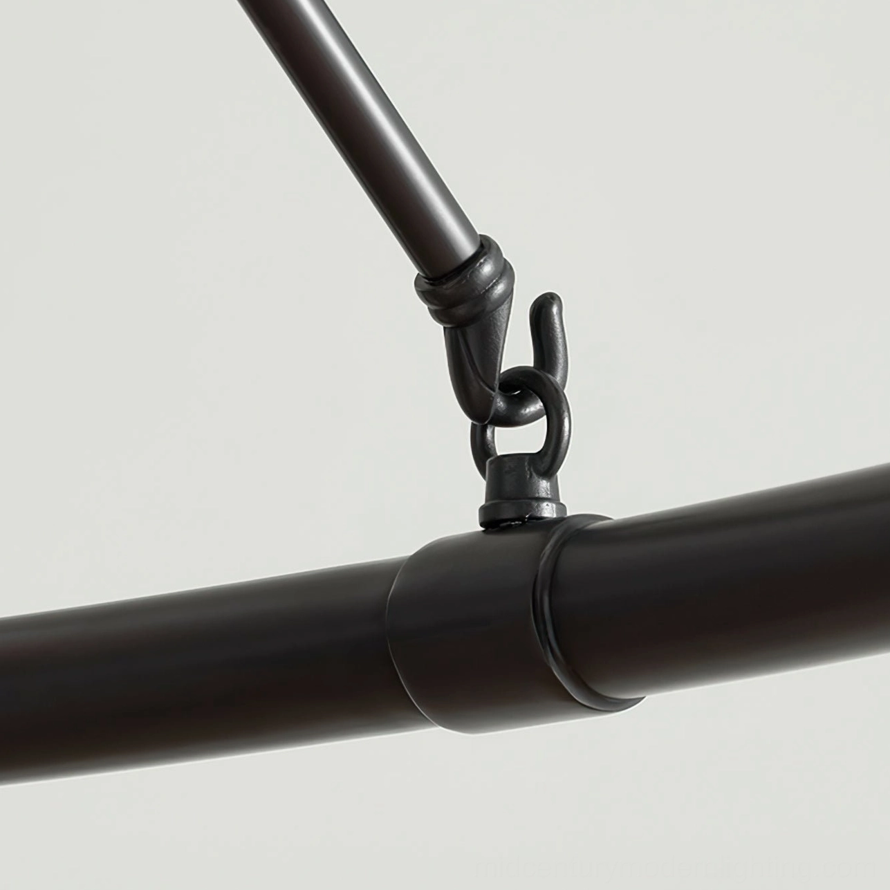 Black matte chandelier hardware close-up, tubular metal frame with precision joinery detail
