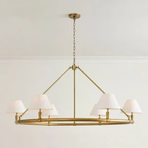 Mid-century modern brass chandelier with white tapered shades displayed on minimalist interior wall