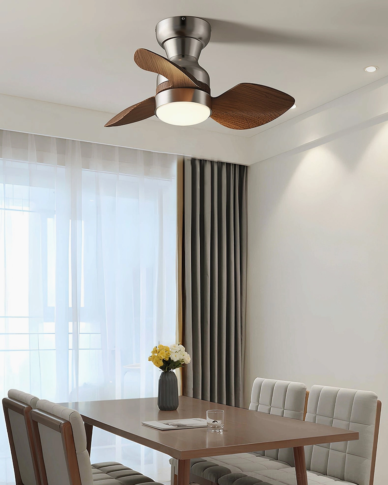 Haiku compact ceiling fan light in contemporary dining room, brushed silver metal body, walnut wood blades, quiet DC motor operation