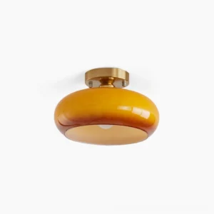 Hailie mid-century modern ceiling lamp with warm amber glass disc and brass base in studio lighting