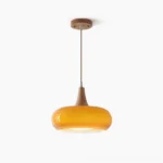 Hailie mid-century modern pendant lamp with warm amber glass shade and walnut wood frame, studio front view