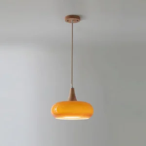 Single head Hailie pendant lamp in orange amber finish with natural wood accents, overhead studio angle