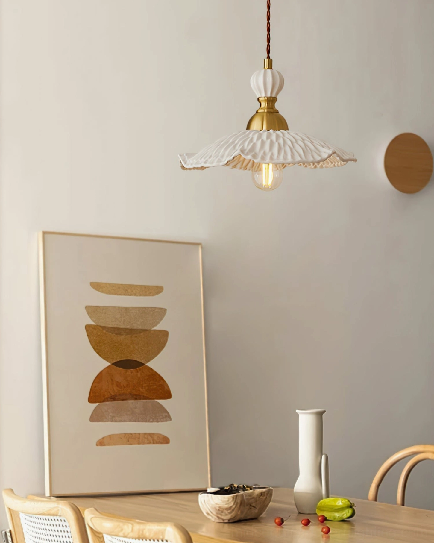 Hand-finished ceramic pendant showing sculptural craft quality with brass accents and fabric cord