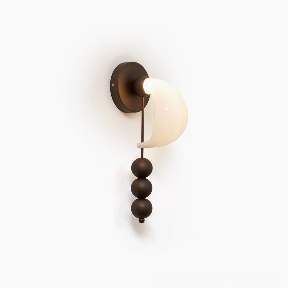 Hand-formed bent glass wall sconce with sculptural brass spheres, antique brass finish showing premium metalwork detail