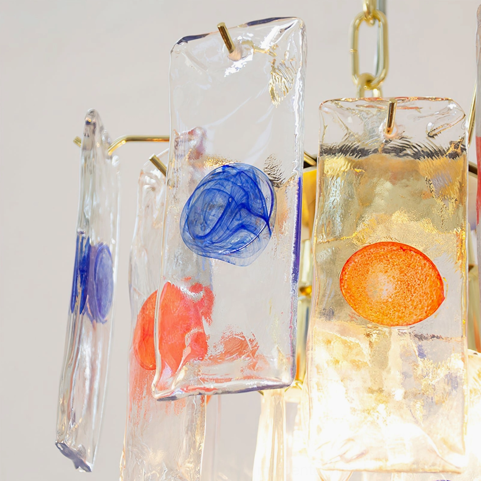 Macro close-up of thick textured glass piece from pendant lamp with blue and orange round decorative elements