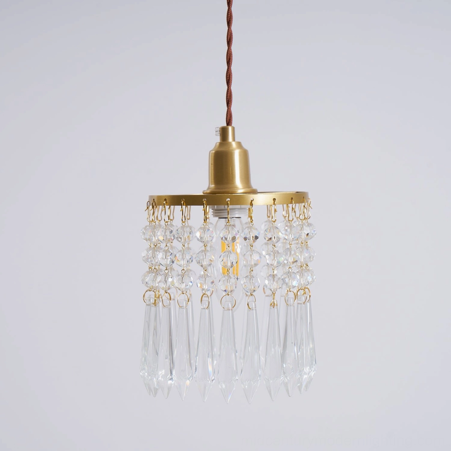 Hanging crystal pendant with gold brass components, ceiling-mounted display