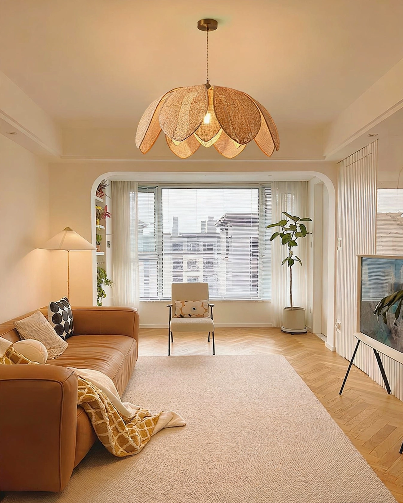 Hanove organic rattan pendant light in spacious minimalist living room with wood flooring and clean modern decor