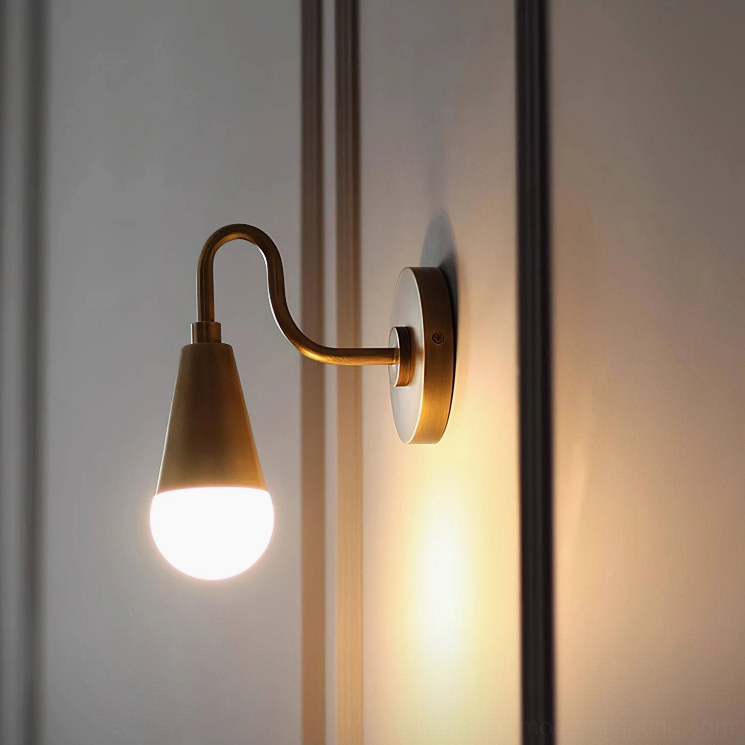 Harlan Gooseneck Wall Sconce side profile illuminated, aged antique brass finish with warm lighting accent, studio background