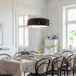 Black Harper pendant light installed in Nordic minimalist dining room, eye-level view illuminating modern dining setup with clean Scandinavian aesthetic