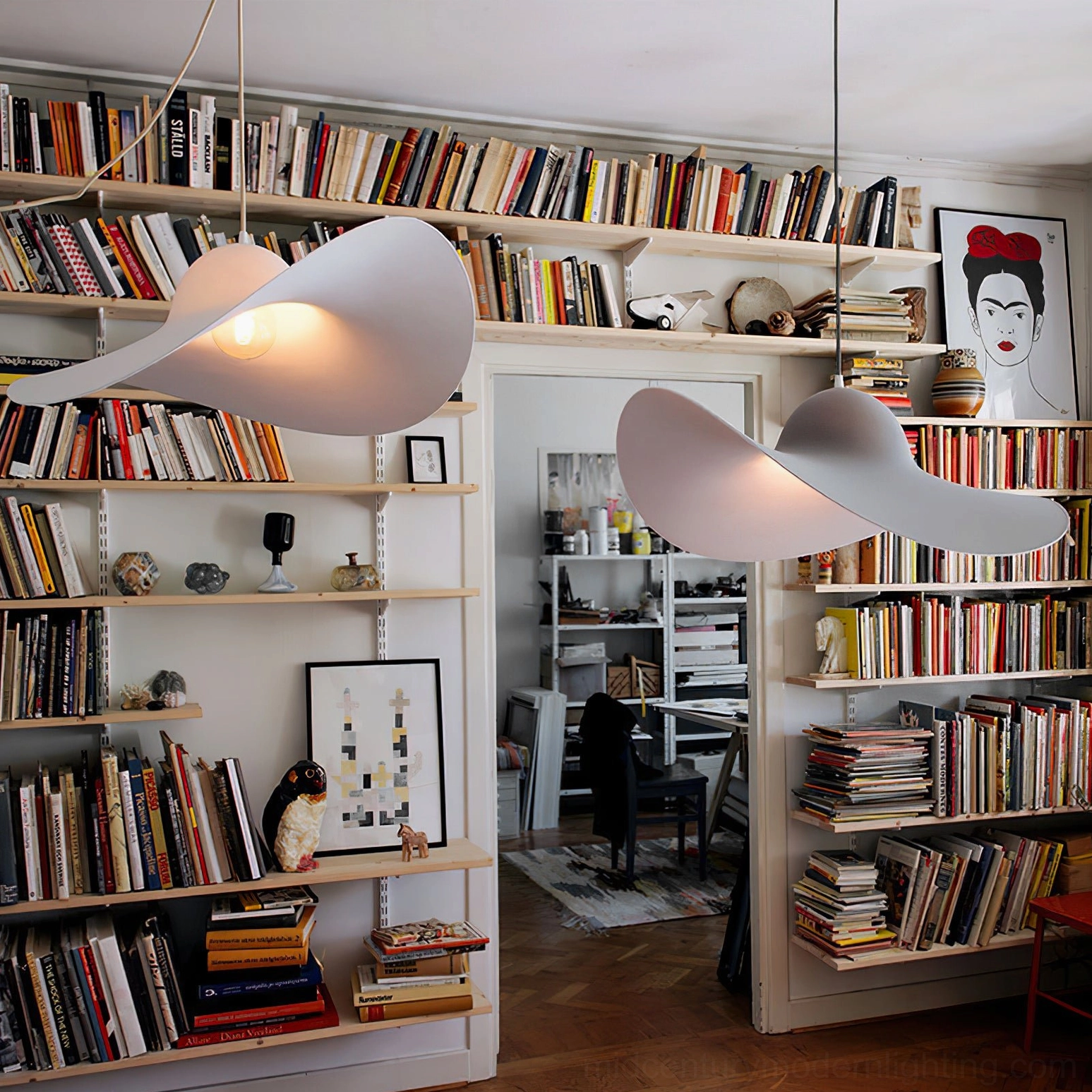 Two hat-shaped pendant lights with warm glowing bulbs in home study with wall bookshelves