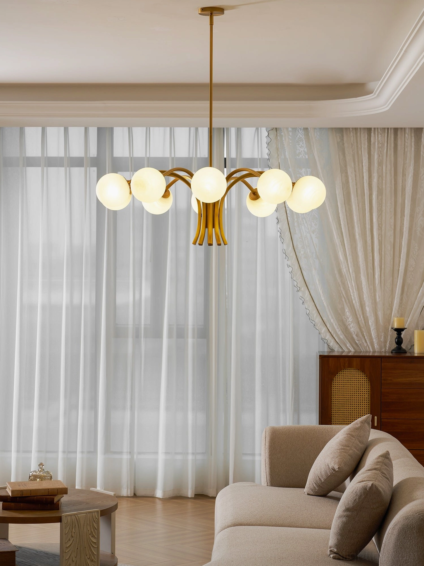 Contemporary brass and glass chandelier with sculptural spherical design, mid-century modern influence