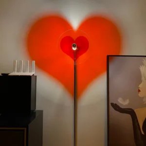 Heart-shaped floor lamp casting warm orange heart shadow on living room wall, modern minimalist interior with corner setting