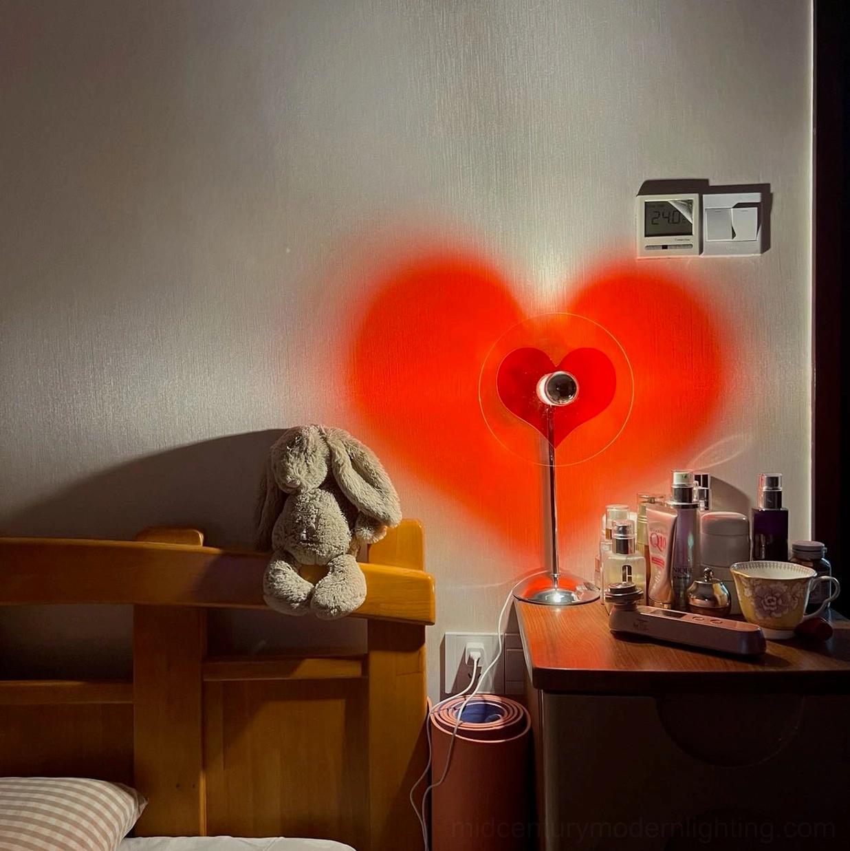 Heart projection table lamp displaying red ambient light effect in modern interior setting