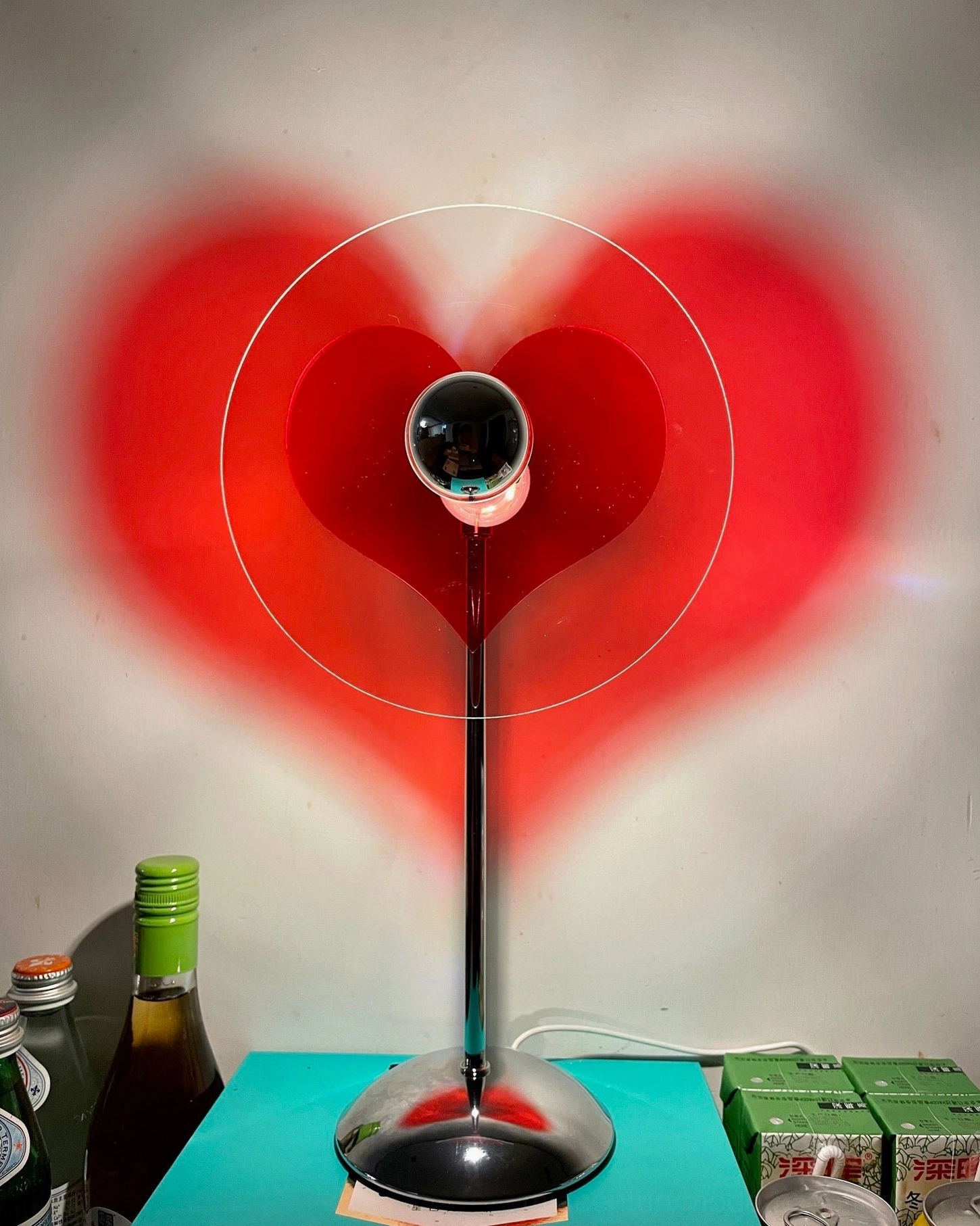 Heart projection table lamp casting romantic red heart shadow in modern home space