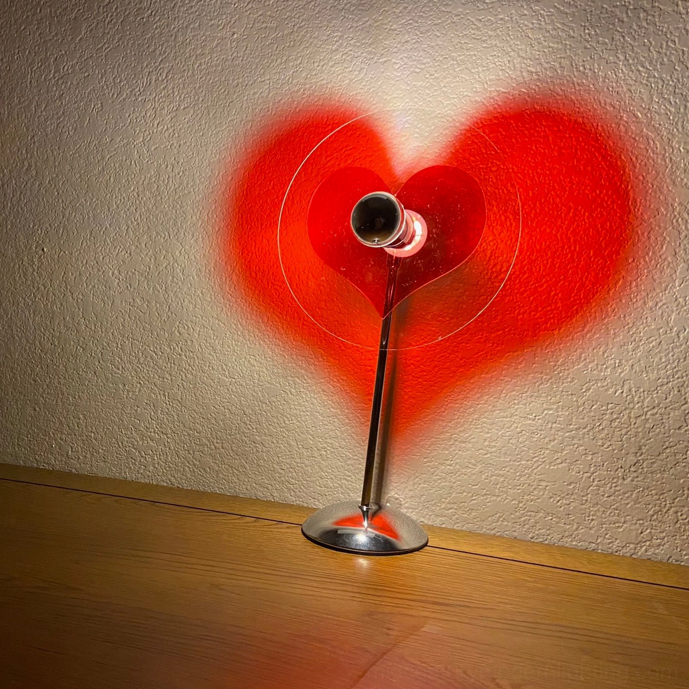 Heart-shaped lamp transforming desk into romantic workspace with ambient heart-shaped projection