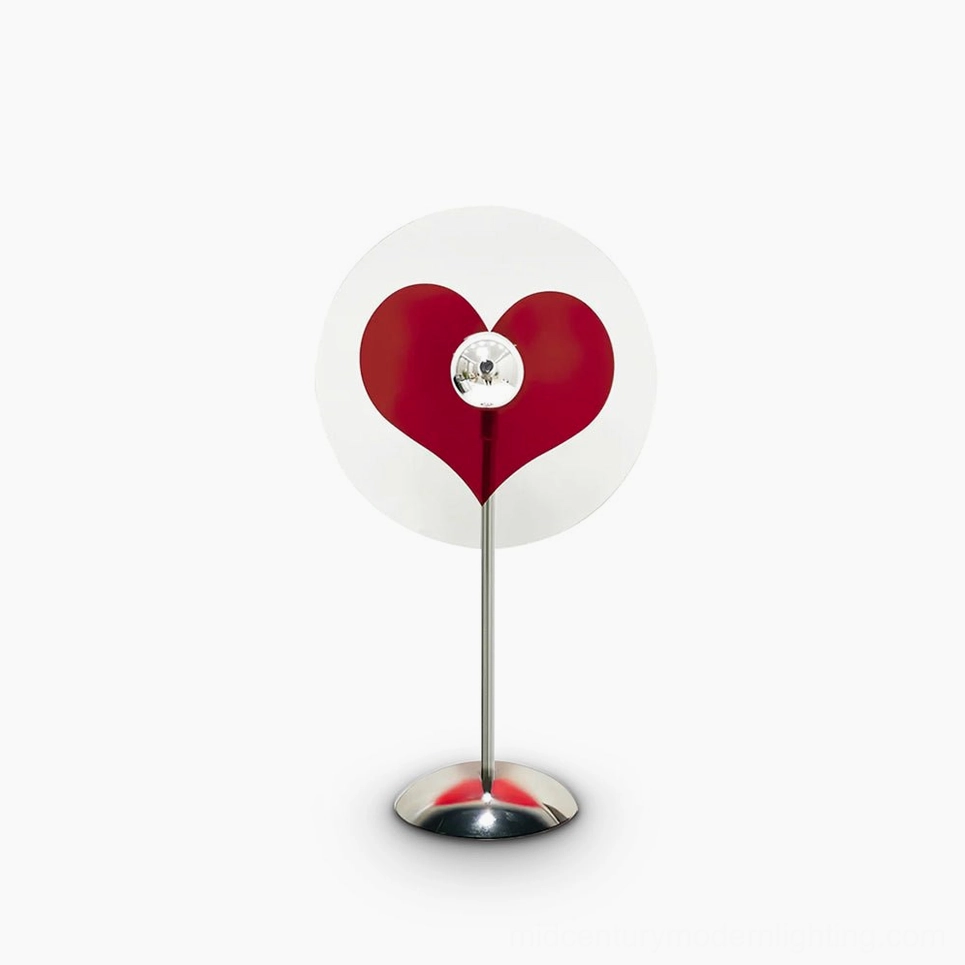 Heart-shaped red LED projection table lamp on white background, minimalist modern design with chrome metal frame and clear acrylic base