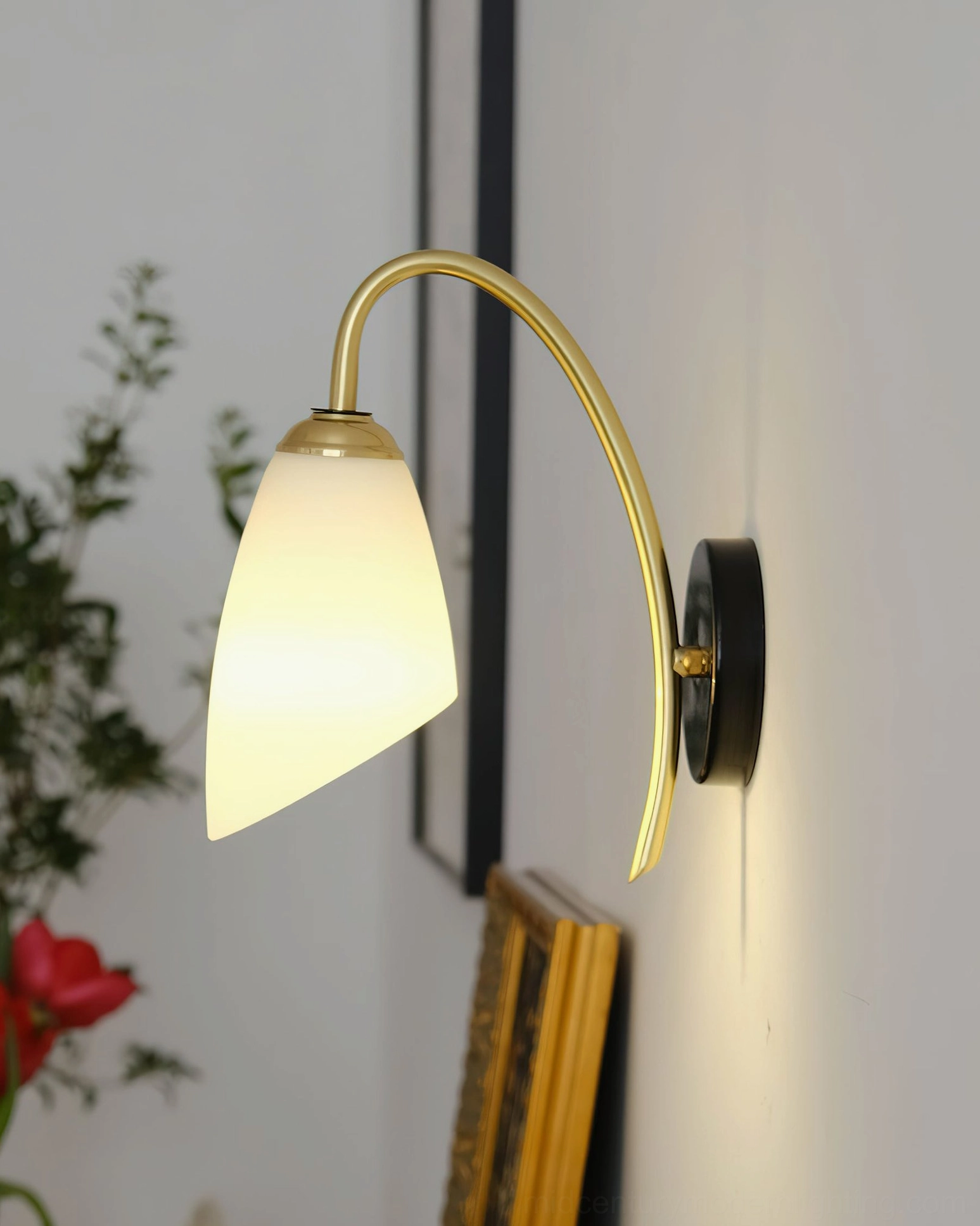 Hector lit wall sconce emitting warm glow with brass arm illuminated against wall frame