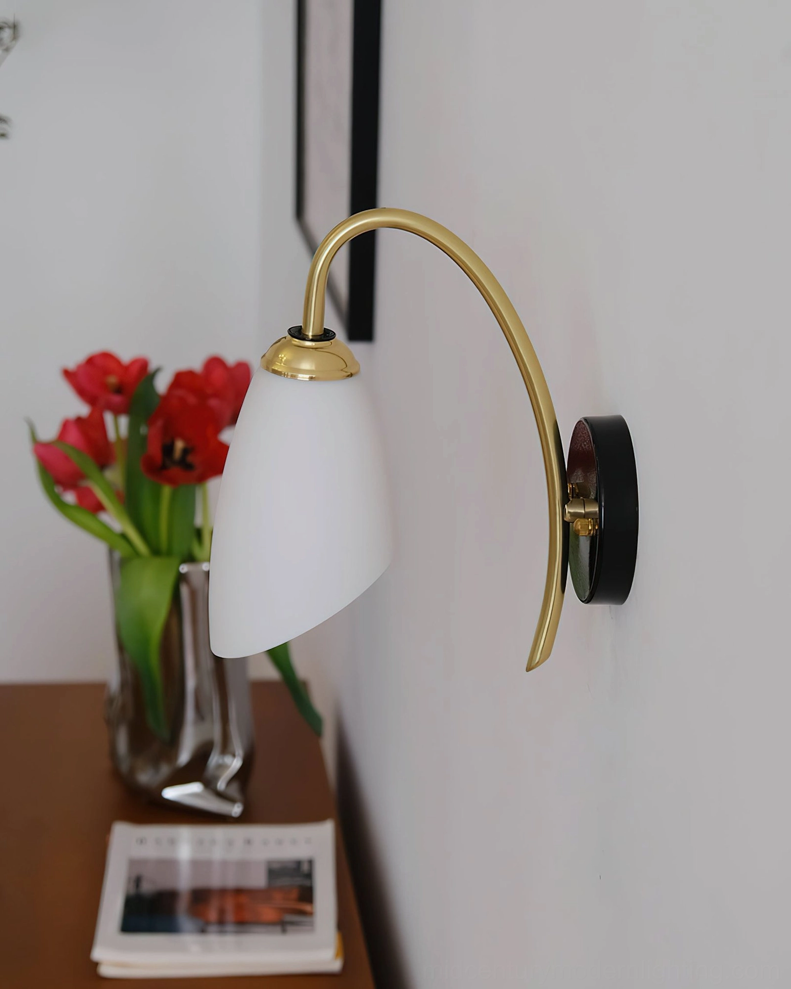Hector brass wall sconce styled with red tulips and tabletop decor arrangement
