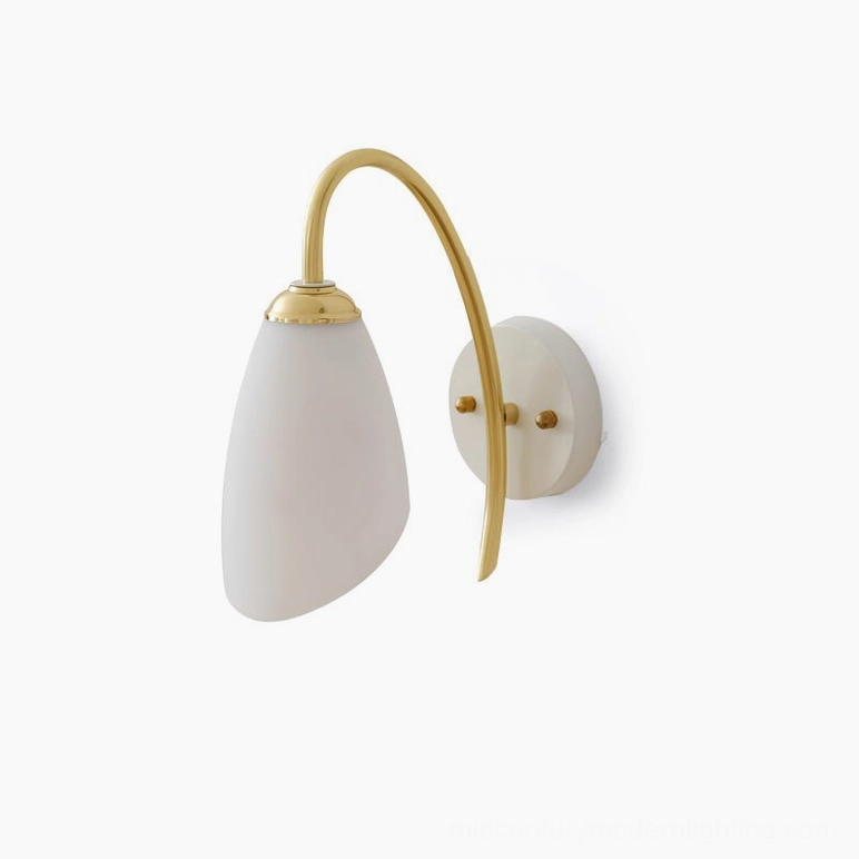 Hector wall sconce with white base and brass curved arm on plain white backdrop