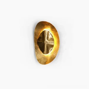 Helios hand-hammered brass wall sconce front view studio shot with warm backlighting highlighting organic oval shape and textured metalwork