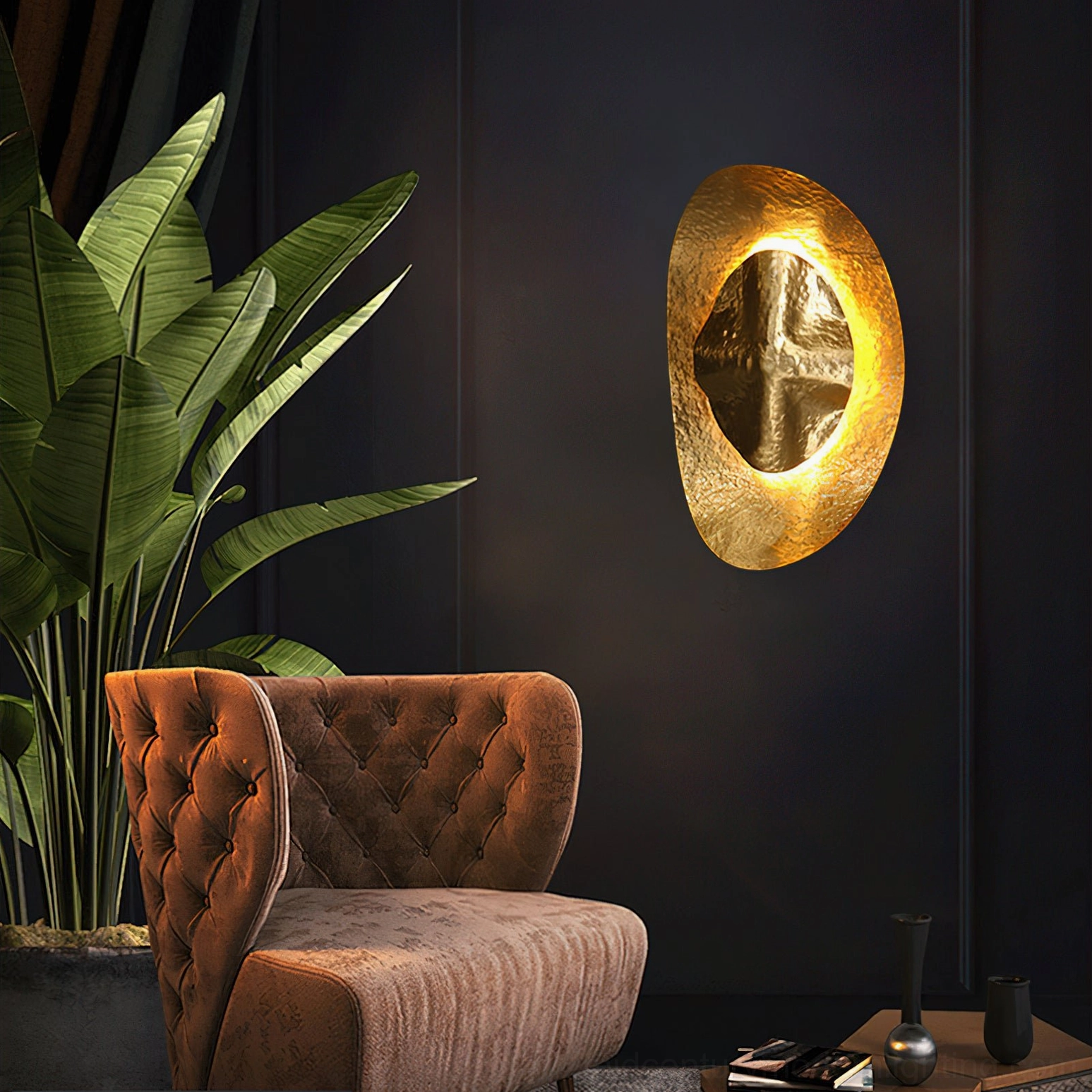 Helios hammered brass sconce mounted on navy accent wall beside velvet lounge chair with warm glowing light in modern luxury lounge