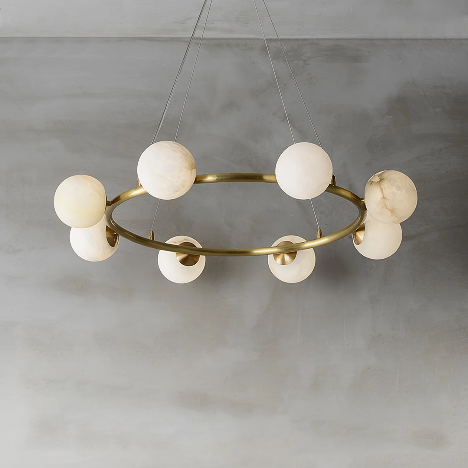 Helix ring pendant chandelier with circular brass ring and evenly spaced alabaster lamp globes, oblique front view luxury minimalist