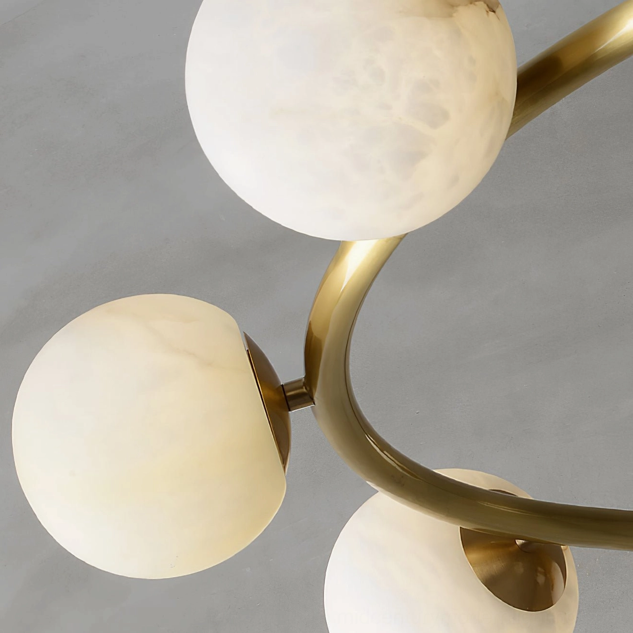 Close-up detail of helix chandelier components showing natural veined alabaster shades and brushed brass frame