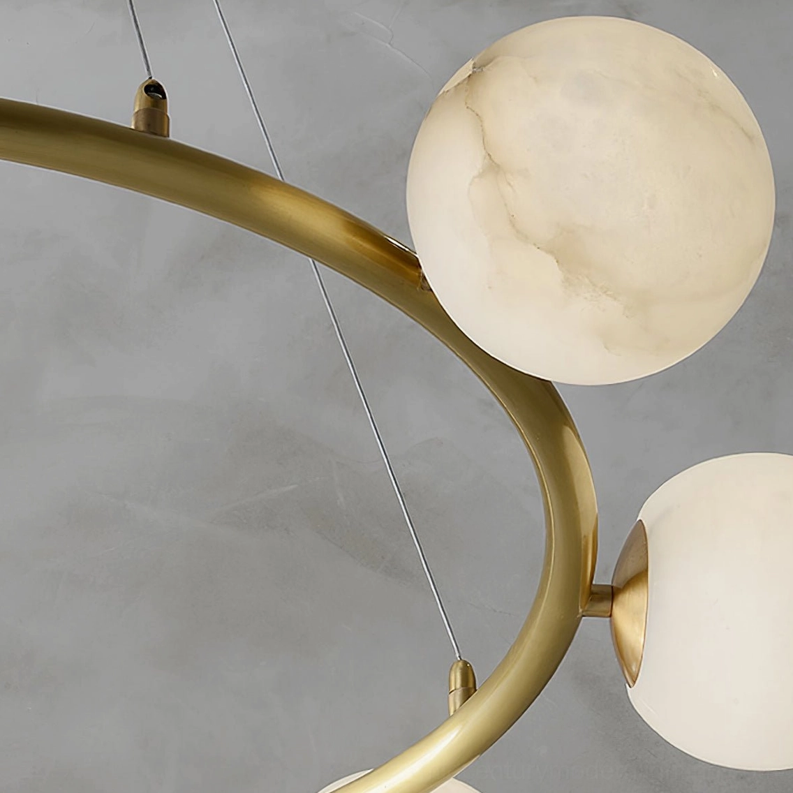 Close-up of helix chandelier arm and alabaster shades showing polished brass hardware and natural stone texture