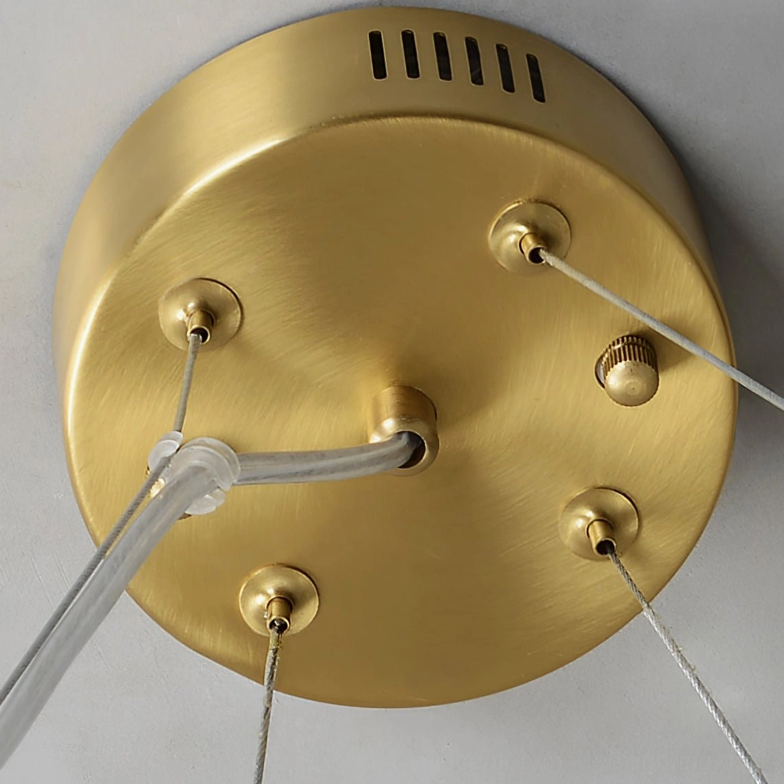 Helix chandelier ceiling mount base with brushed brass finish, cable ports, and heat dissipation vents, top-down detail view