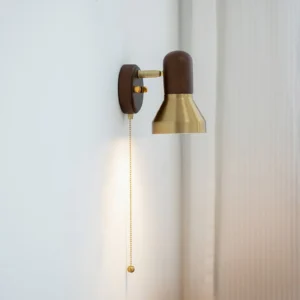 Mid-century wall sconce installed in corner with sheer curtain, showing warm brass and wood lighting effect