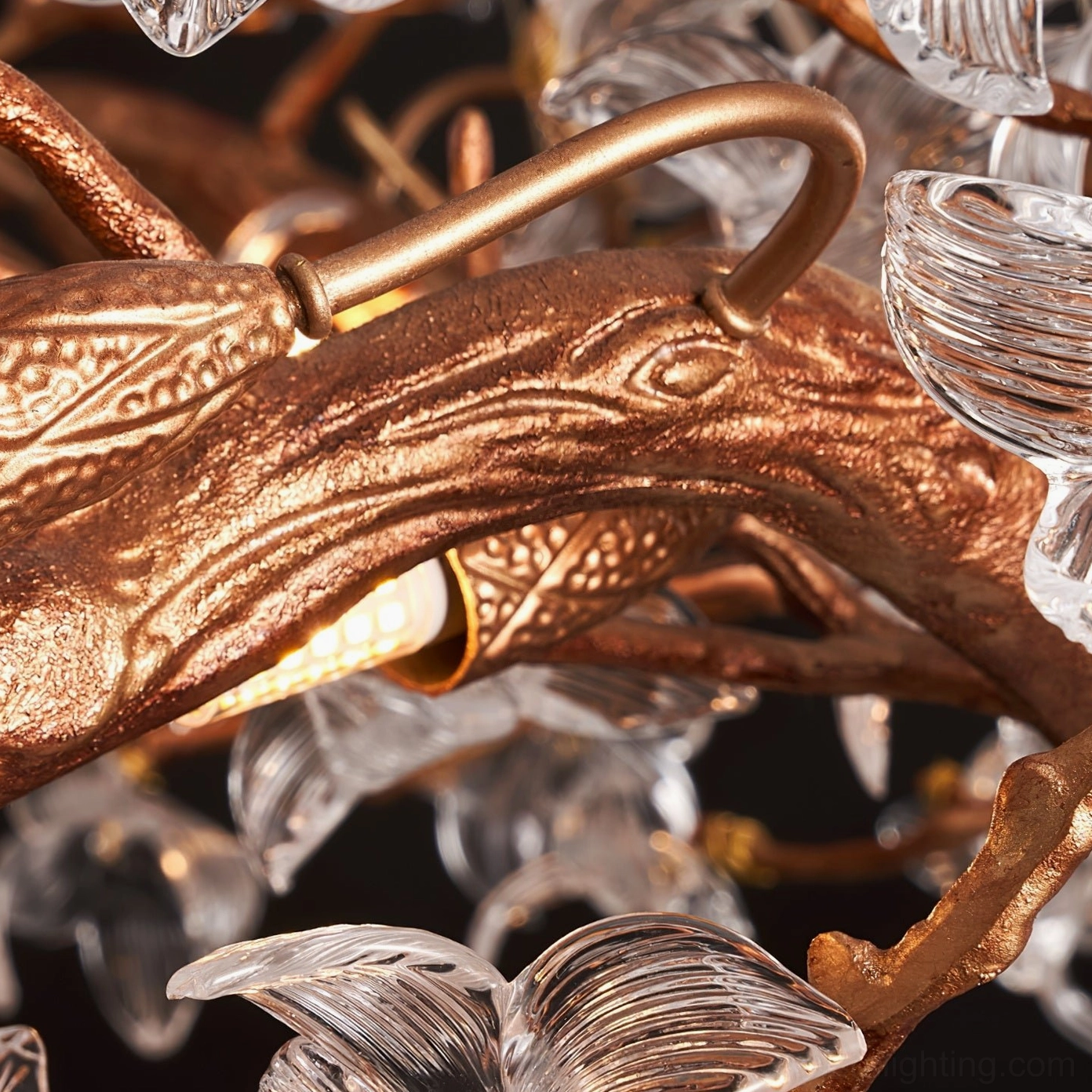 Hibiscus chandelier glowing softly in bedroom creating intimate ambiance with warm brass tone