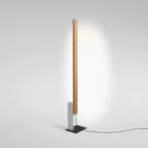 Modern sculptural floor lamp with warm LED light reflecting off wall, minimalist design with wood grain detail