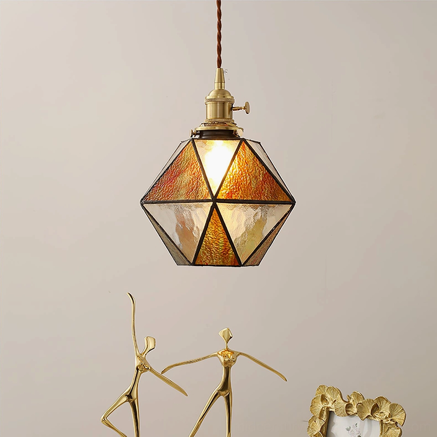 Hiro dual-tone amber stained glass pendant lamp with vintage brass hardware, lower frontal view in vintage home setting with ornaments