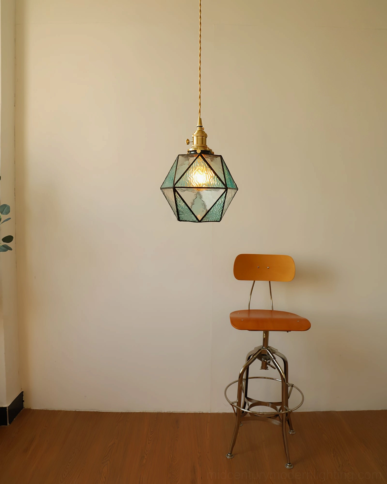 Hiro compact mint glass pendant lamp in minimalist room with wooden floor and vintage industrial stool, wide distant view
