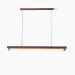 Hiromi linear pendant light in walnut wood finish suspended from adjustable cables against white studio background