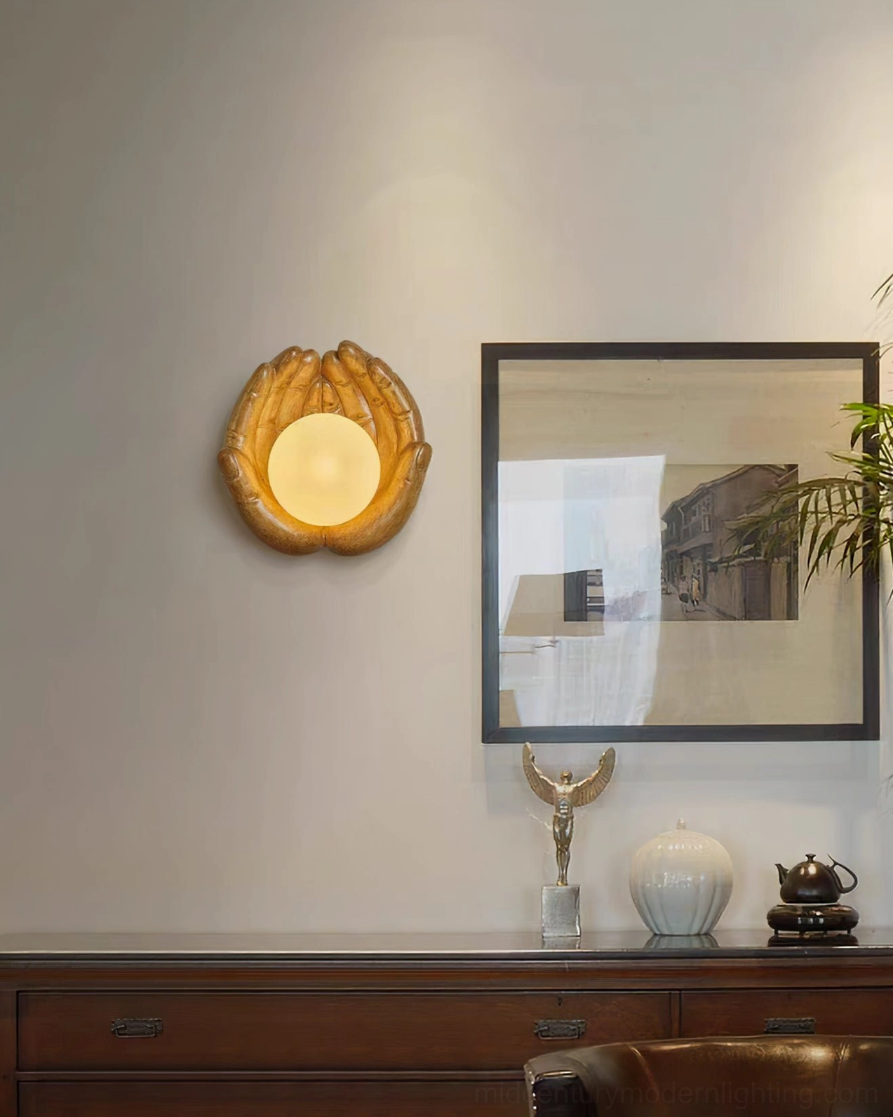Holding hands wall lamp in warm wood tone mounted in modern living room with sideboard and wall decor, showing in-situ placement