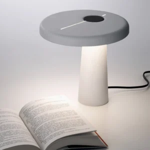 Modern Hoop LED table lamp in two-tone gray and white sitting on desk with open book, minimal workspace