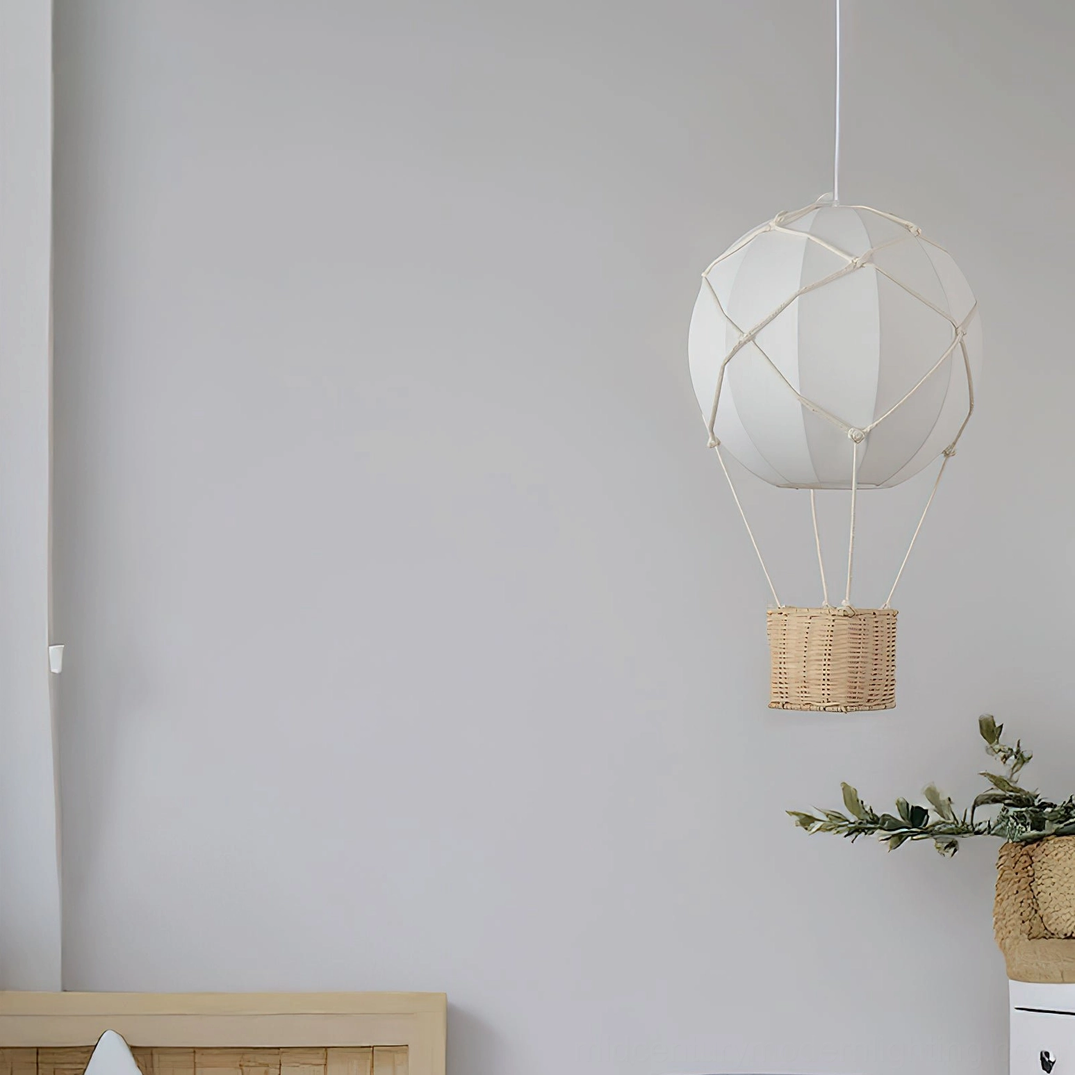 Hot air balloon pendant light side profile in minimalist bedroom corner showcasing white fabric and natural rattan