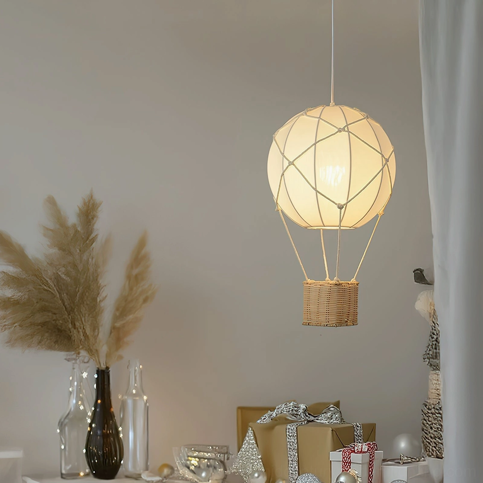 Hot air balloon pendant light suspended above festive bohemian table with dried florals and neutral décor