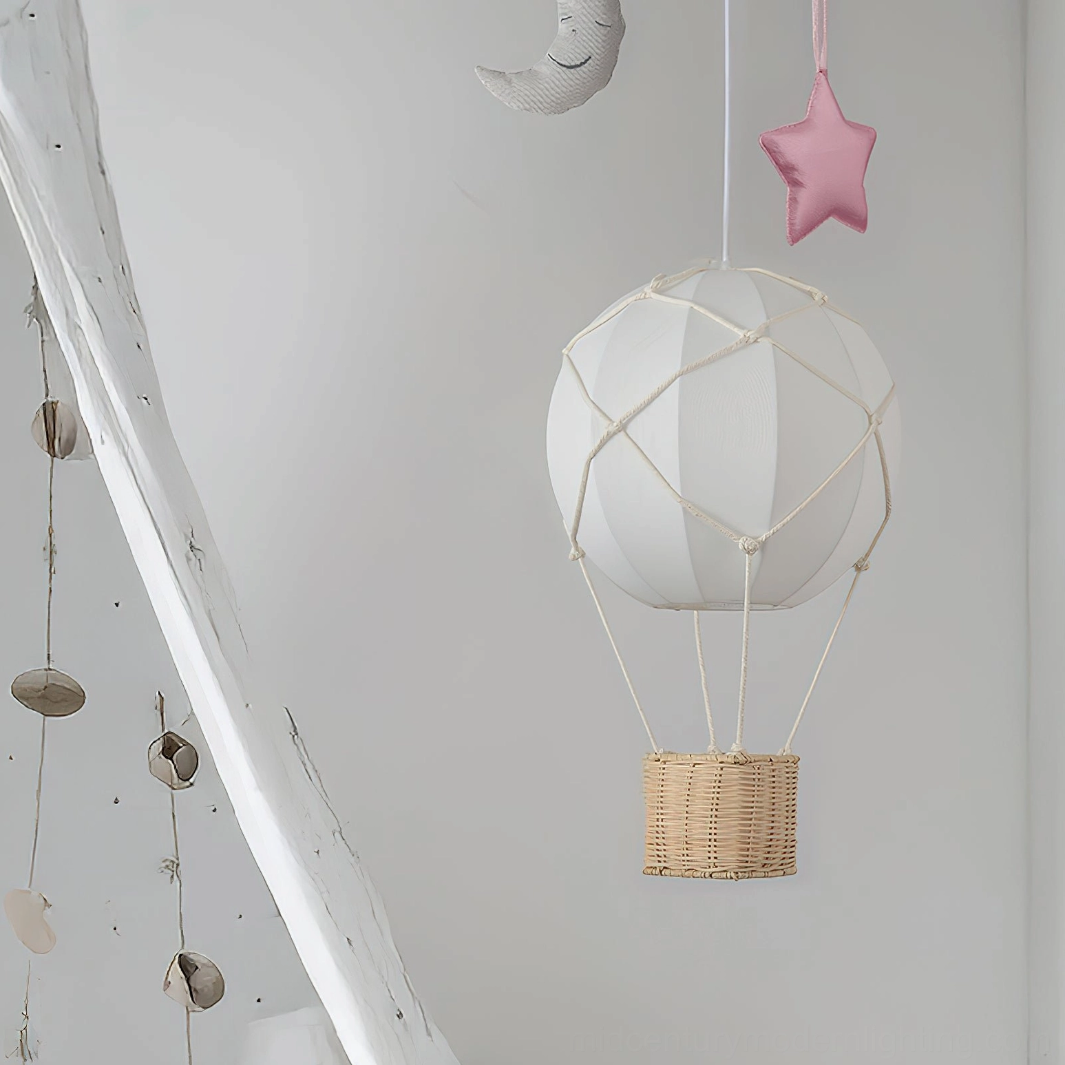 Hot air balloon pendant light in kids boho playroom with hanging moon ornaments and white rope frame