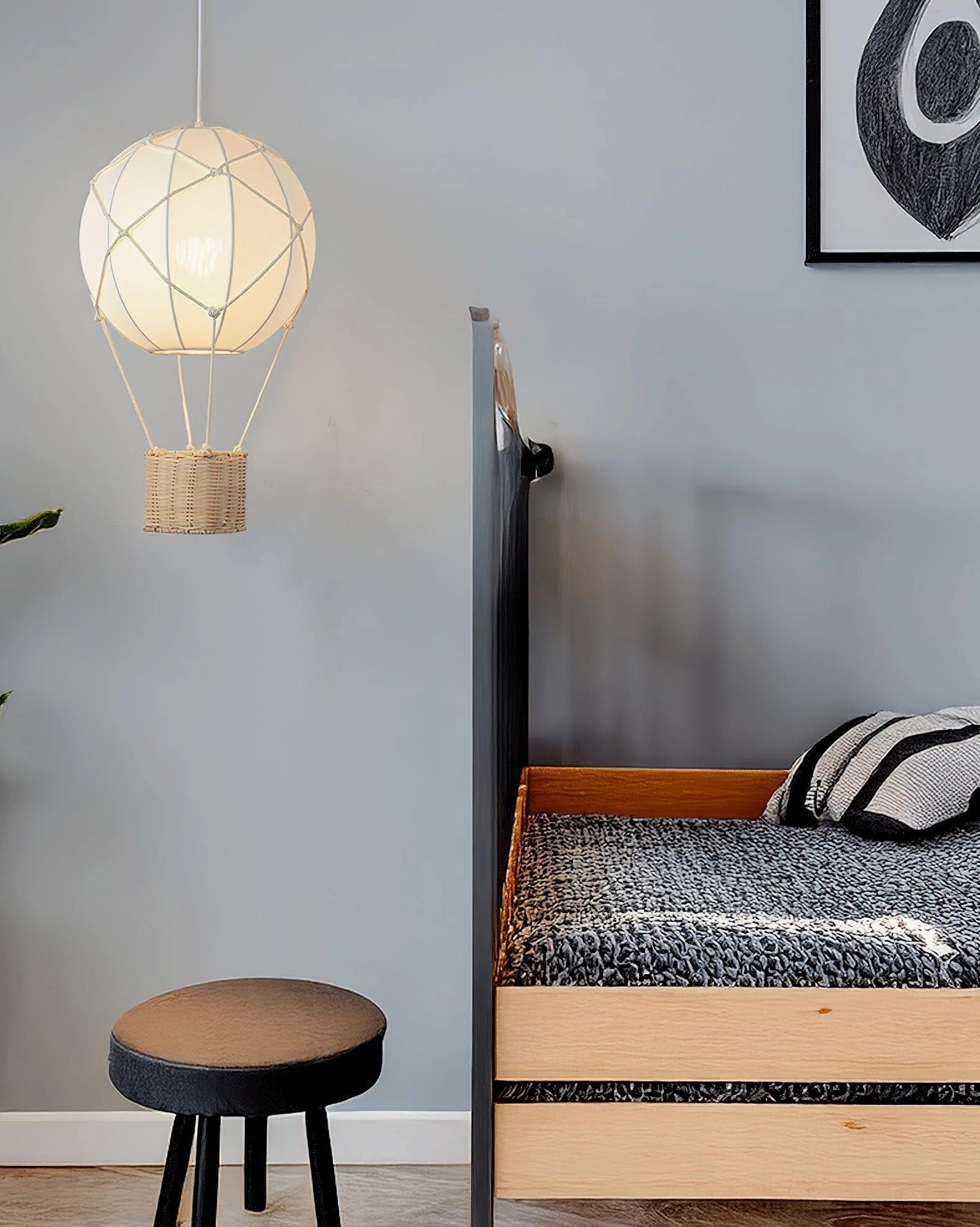 Hot air balloon pendant light in Nordic style kids bedroom above single bed with minimal décor and wall art