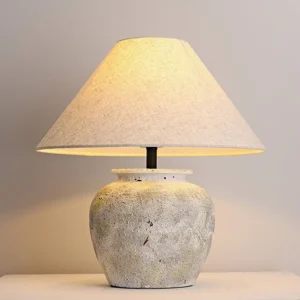 Close-up of Houa ceramic lamp base showing distressed textured finish and warm ambient lighting