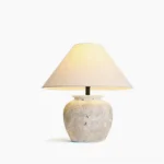 Houa ceramic table lamp with aged sandstone base and natural linen shade - front studio view