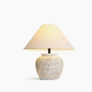 Houa ceramic table lamp with aged sandstone base and natural linen shade - front studio view