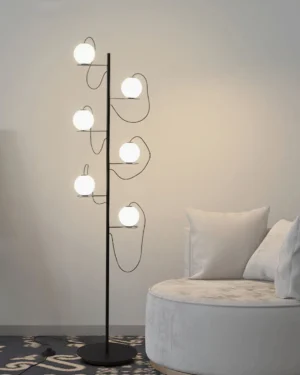 Hubble Bubble modern floor lamp positioned in minimalist living room corner next to round fabric accent chair, providing warm ambient lighting