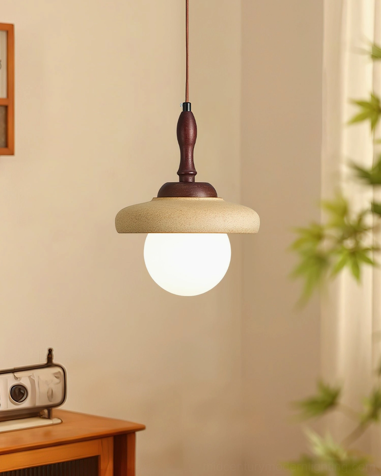 Humboldt walnut wood pendant light close-up in dining nook with plants, detail view